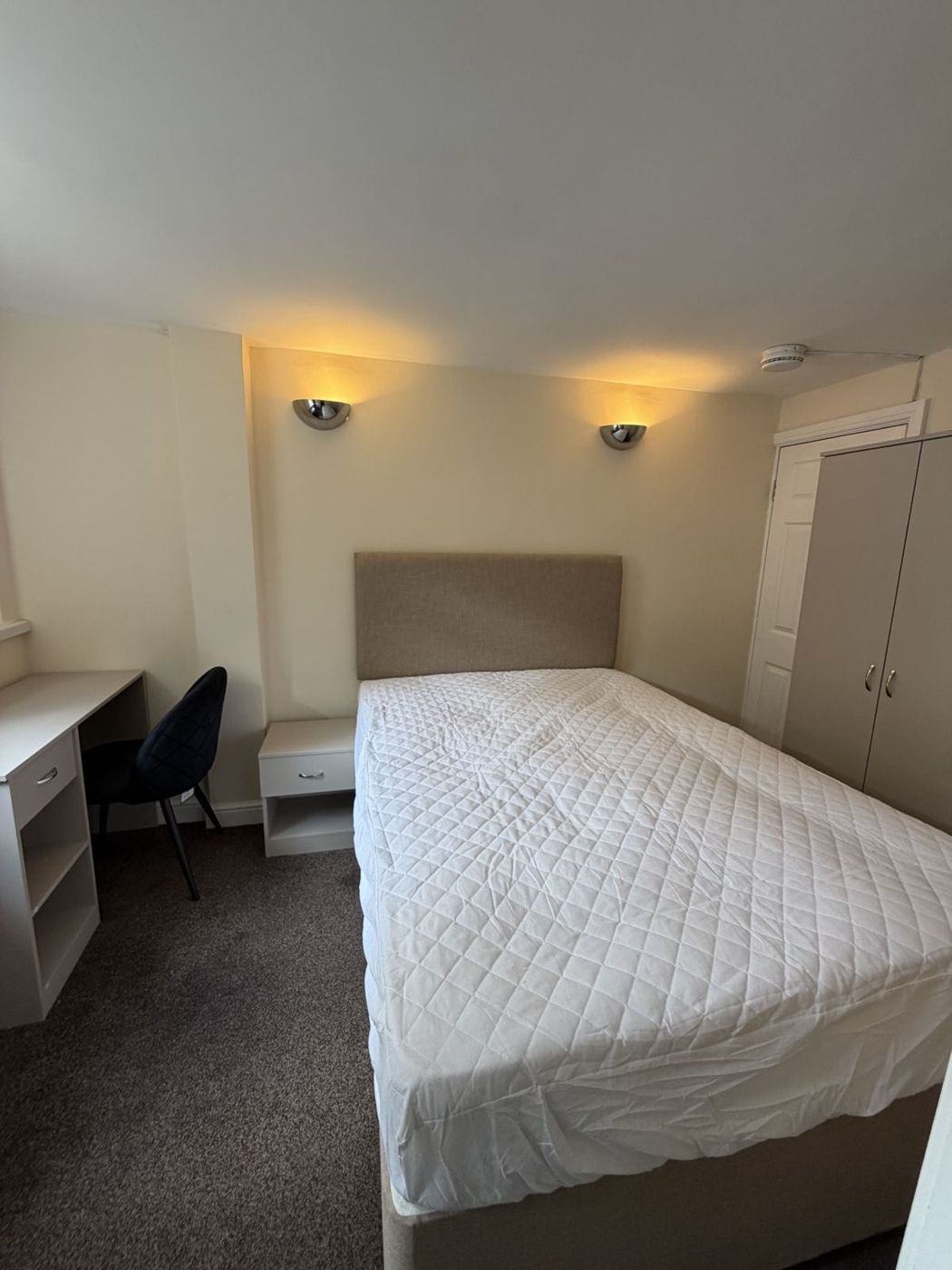 Single bedroom with desk, wardrobe and wall lights