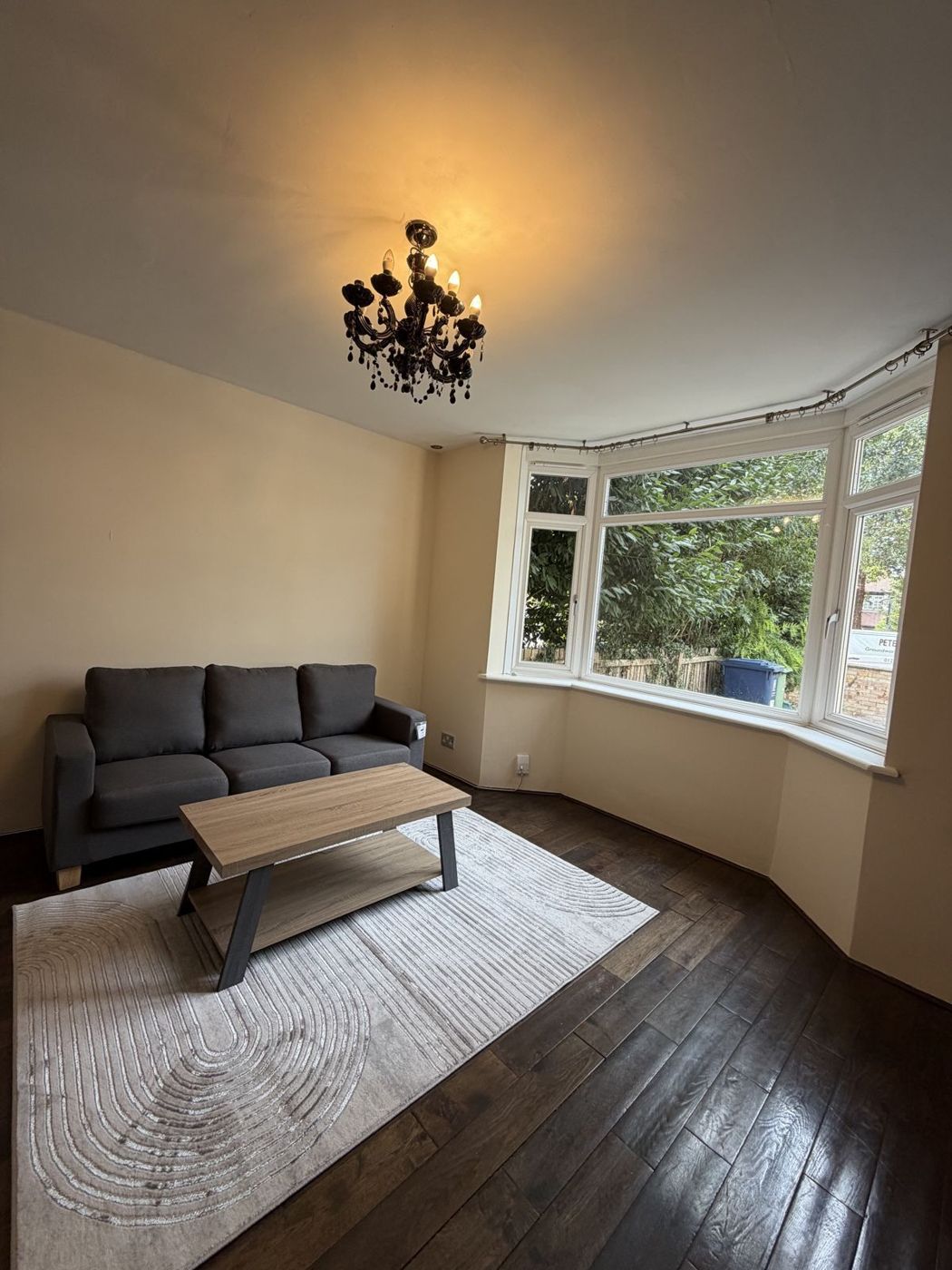 Lounge with sofa, bay window and wood floor